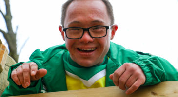 A young man with down's syndrome smiles