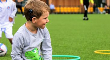 A young boy smiles with a football