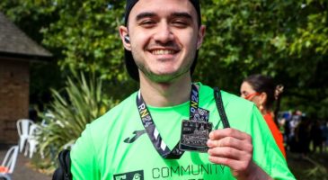 man in green top with medal around his neck