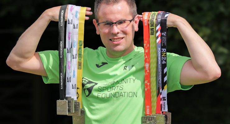 Folded arms of a man in a green t-shirt