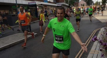 Man in green, running and high fiving the crowd