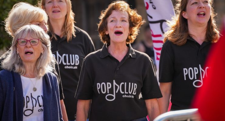 women singing with pop club on their tshirt