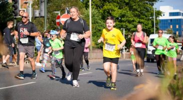 children and adults running down a road